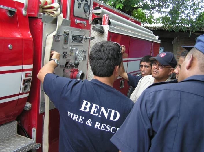 A Bend firefighter training Condega volunteers on a fire engine pump panel
